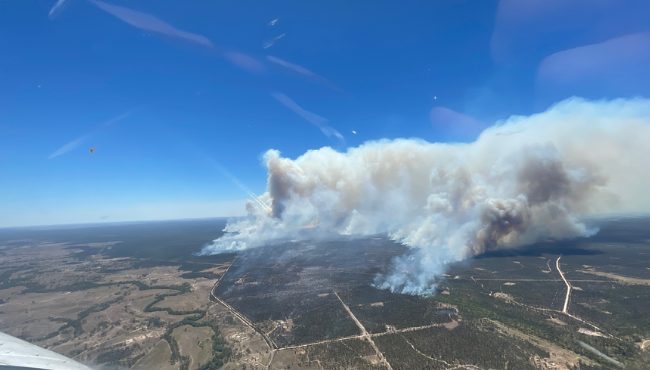 Aerial photograph of smoke plumes from bushfire in a rural setting 