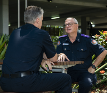 QFD Chaplain sitting with QFD personnel