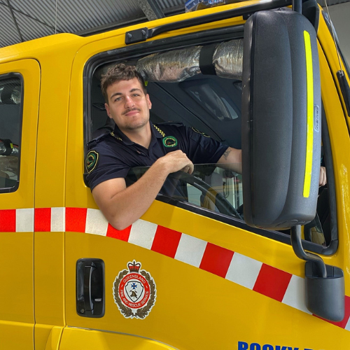 Camden in his uniform in from of a RFSQ yellow truck