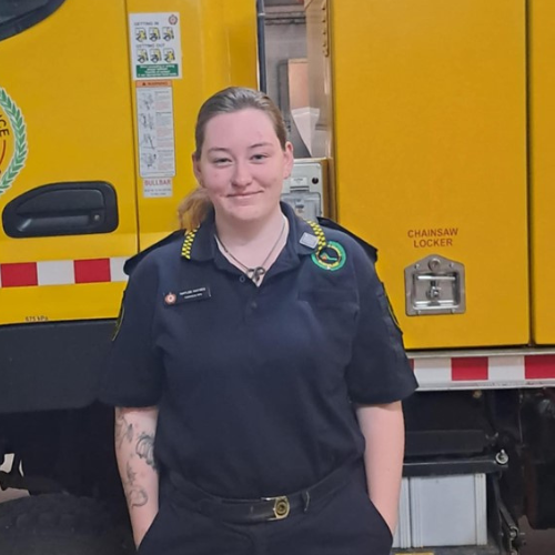 Haylee in her uniform in from of a RFSQ yellow truck